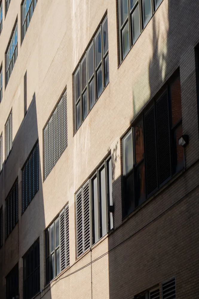 Light and shadow across the windows of a pale stone building